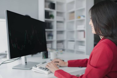 Borsa grafik ekranına bakan Asyalı kadın, borsa işadamı borsa yükselme ve düşüş grafiğini analiz eden, borsa yatırımcısı, kar getiren. yatırım kavramı.