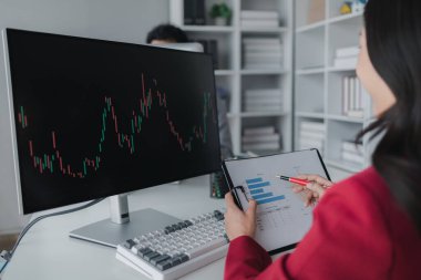 Borsa grafik ekranına bakan Asyalı kadın, borsa işadamı borsa yükselme ve düşüş grafiğini analiz eden, borsa yatırımcısı, kar getiren. yatırım kavramı.