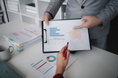 İki işadamı şirketin finansal belgelerini inceliyor. Büyüyen ve karlı bir şirket için işletme ve pazarlama planlama toplantıları. İş toplantısı konsepti.