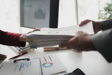 İki şirket çalışanı birbirine evrakları veriyor pazarlama personeli pazarlama analiz belgelerini sunum için bölüm başkanlarına teslim ediyor. Pazarlama analizi ve planlama kavramları.