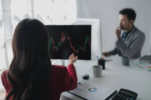 Asian woman looking at stock market graph screen, stock market businessman analyzing stock market rise and fall chart, stock market investor, profit making. investment concept.