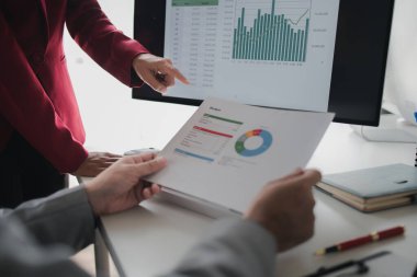 Pazarlama ve satış sonuçlarının veri tabanlarına bakan iki kişi, yöneticiler, bölüm başkanları ve çalışanlar arasındaki iş sonuçlarının analizi,.