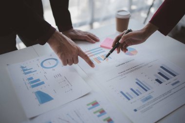 İki işadamı şirketin finansal belgelerini inceliyor. Büyüyen ve karlı bir şirket için işletme ve pazarlama planlama toplantıları. İş toplantısı konsepti.