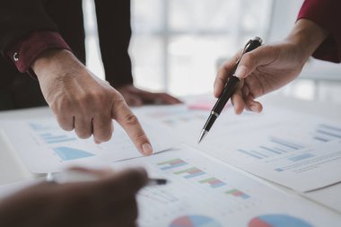 İki işadamı şirketin finansal belgelerini inceliyor. Büyüyen ve karlı bir şirket için işletme ve pazarlama planlama toplantıları. İş toplantısı konsepti.