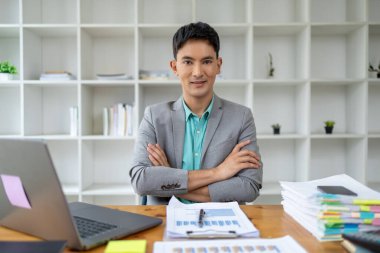 Kurumsal ofiste Asyalı bir adam, bir şirket sahibi iş adamı ofiste oturur, profesyonel bir yönetici şirketi yönetir, işletmeyi yönetir ve kar eder. Şirket yöneticilerinin fikirleri..