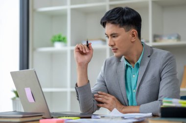 Kurumsal ofiste Asyalı bir adam, bir şirket sahibi iş adamı ofiste oturur, profesyonel bir yönetici şirketi yönetir, işletmeyi yönetir ve kar eder. Şirket yöneticilerinin fikirleri..