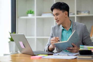 Kurumsal ofiste Asyalı bir adam, bir şirket sahibi iş adamı ofiste oturur, profesyonel bir yönetici şirketi yönetir, işletmeyi yönetir ve kar eder. Şirket yöneticilerinin fikirleri..