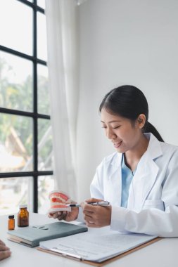 Kadın diş hekimi, hastanın dişlerini kontrol ediyor, dişçi, hastanın semptomları ve endodontik tedavi yönergeleri hakkında tavsiye veriyor. Diş tedavisi kavramı.