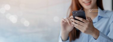 Akıllı telefonu olan Asyalı bir kadın, mağaza değerlendirmelerini ve online alışveriş siparişlerini değerlendiriyor. Mağazalara yıldız vermek, servisi kullanma kararları için yapılan bir değerlendirmedir. Hizmet derecesi kavramı.