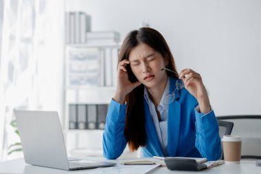 Girişimci şirkette çalışan Asyalı bir kadın, iş kadını uzun çalışma saatleri ve çalışanlar arasında ofis sendromu nedeniyle stres altında ve vücut ağrısı çekiyor. Ofis sendromu konsepti ve sıkı çalışma.