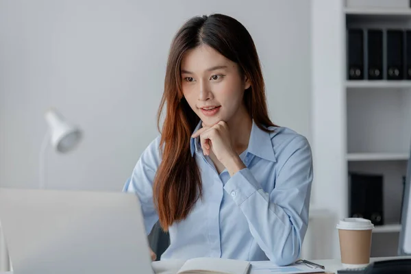 Asian woman sitting in startup company office, businesswoman, executive and investor in business and stocks, management of young people, new concept. Start-up company management concepts.