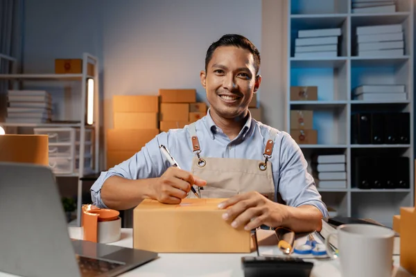 Asian business owners sell products on websites and online platforms. Business owners sell their products online and pack the products into parcels to deliver to customers via courier service.