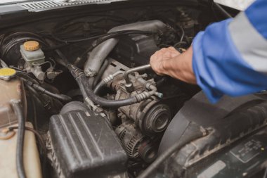 Tamirci, merkezden tamir için gelen bir arabanın motorunu inceliyor. Profesyonel motor uzmanı, araba tamiri, araba arızası. Araba bakım ve onarım konsepti.