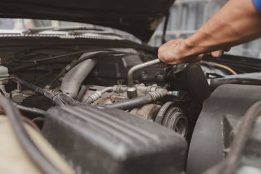 Tamirci, merkezden tamir için gelen bir arabanın motorunu inceliyor. Profesyonel motor uzmanı, araba tamiri, araba arızası. Araba bakım ve onarım konsepti.