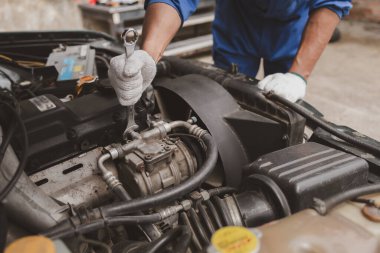 Tamirci, merkezden tamir için gelen bir arabanın motorunu inceliyor. Profesyonel motor uzmanı, araba tamiri, araba arızası. Araba bakım ve onarım konsepti.