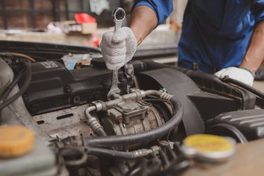 Tamirci, merkezden tamir için gelen bir arabanın motorunu inceliyor. Profesyonel motor uzmanı, araba tamiri, araba arızası. Araba bakım ve onarım konsepti.