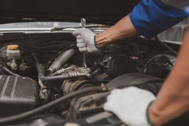 Tamirci, merkezden tamir için gelen bir arabanın motorunu inceliyor. Profesyonel motor uzmanı, araba tamiri, araba arızası. Araba bakım ve onarım konsepti.