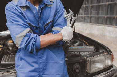 Tamirci, merkezden tamir için gelen bir arabanın motorunu inceliyor. Profesyonel motor uzmanı, araba tamiri, araba arızası. Araba bakım ve onarım konsepti.