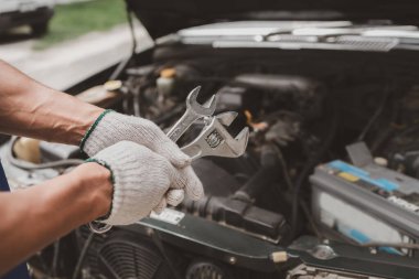 Tamirci, merkezden tamir için gelen bir arabanın motorunu inceliyor. Profesyonel motor uzmanı, araba tamiri, araba arızası. Araba bakım ve onarım konsepti.