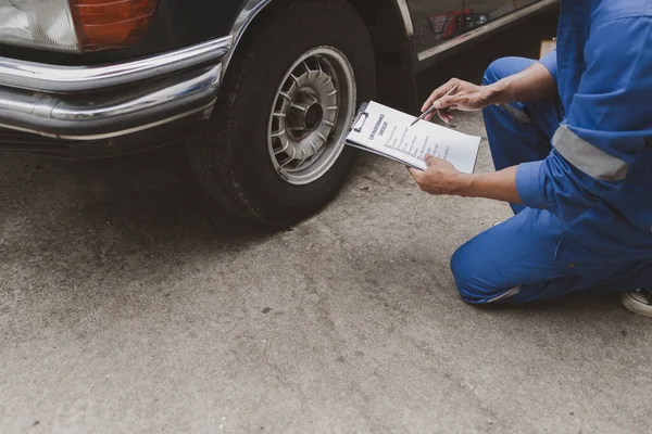Car mechanic is inspecting tires and replacing worn tires through long hours of work, car repairs, car breakdowns, punctured tires. Concept of car tire maintenance and car repair.