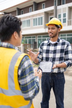 The home design architects are reviewing the house plan draft, the project commissioned by the client, and the custom design before delivery. Interior design and decoration ideas.