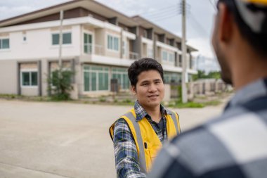 Mimar ve mühendis iş sahasında el sıkışıyor, müşteri tarafından sipariş edilen proje ve teslimattan önce özel tasarım. İç tasarım ve dekorasyon fikirleri.