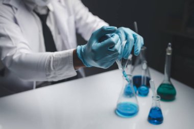 Laboratuvar asistanı, tıp bilimcisi, kimya araştırmacısı kan örneğinde cam bir tüp tutuyor, kimyasal bir deney yapıyor ve hastanın kan örneğini inceliyor. Tıp ve araştırma konsepti.