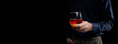 Bir adam viski içer, bir işadamı ağır bir işi bitirdikten sonra ofiste oturup viski içmenin stresinden kurtulur, sarhoş bir adam. Alkol içme konsepti.