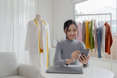 Asyalı kadınların tasarım ve terzilik dükkanları, kadın giyim mağazaları sahipleri, İnternet sitelerinde kıyafet satışı ve sosyal medya aracılığıyla canlı satışlar var. İnternette kıyafet satmak ve satmak için iş fikirleri.