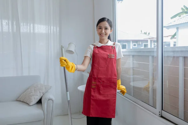 Asian woman cleaning staff, company office cleaning maid, maintaining cleanliness in the office. Cleaning concept and housekeeper taking care of cleanliness and order in the office.