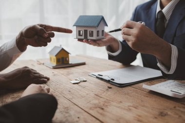 Projede gayrimenkul ve ev satışları düzenleniyor. Birkaç kez gidip bir satıcıyla ev almayı tartışmışlar. Konut projesi satıcısı ev alıp satmanın detaylarını açıklıyor.