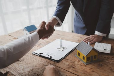 Projede gayrimenkul ve konut satışları düzenleniyor, konut projesi satıcıları ev satışlarının ayrıntılarını, satış sözleşmesini imzaladıktan sonra çalışan ve müşterilerle el sıkışmayı anlatıyor.