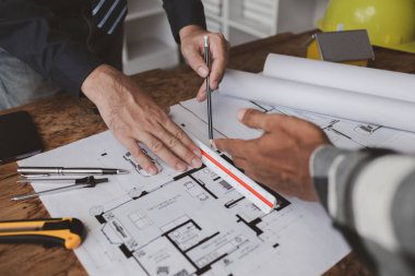 The home design architects are reviewing the house plan draft, the project commissioned by the client, and the custom design before delivery. Interior design and decoration ideas.