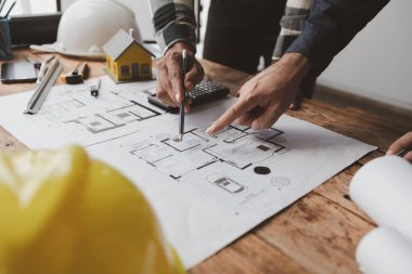 The home design architects are reviewing the house plan draft, the project commissioned by the client, and the custom design before delivery. Interior design and decoration ideas.