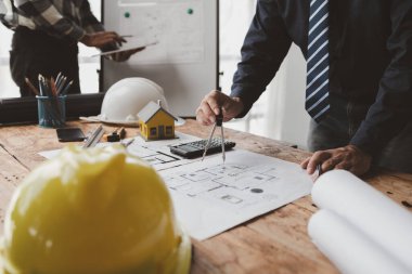 The home design architects are reviewing the house plan draft, the project commissioned by the client, and the custom design before delivery. Interior design and decoration ideas.