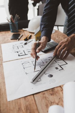 Mimarlar müşteriler için ev planları tasarlıyor, inşaat standartlarına göre planlar çiziyor ve uygun malzemeler seçiyor, profesyonel mühendislerin planlarını kontrol ediyor. Ev tasarımı fikirleri.