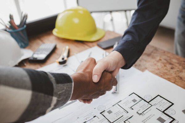 Planning meeting to edit the plans together between architects and engineers, designing the building according to standards and setting up the structure. Real estate design and construction concepts.