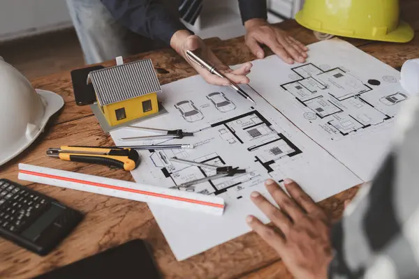 The home design architects are reviewing the house plan draft, the project commissioned by the client, and the custom design before delivery. Interior design and decoration ideas.