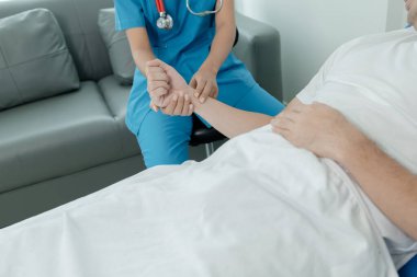 Hasta, doğru ve uygun tedaviyi teşhis etmek için bir doktorla birlikte yatağında yatıyor ve semptomlar hakkında bilgi istiyor. Tıbbi tedavi kavramı.