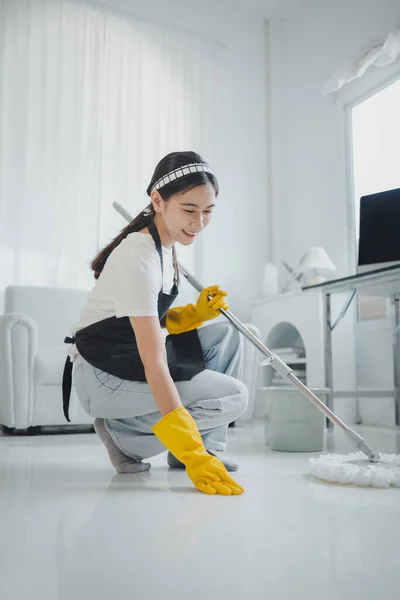 The cleaning staff is checking the floor to see if it is clean or not, Wear rubber gloves and an apron and work with a happy smile, working with cleaning chemicals, cleaning idea.
