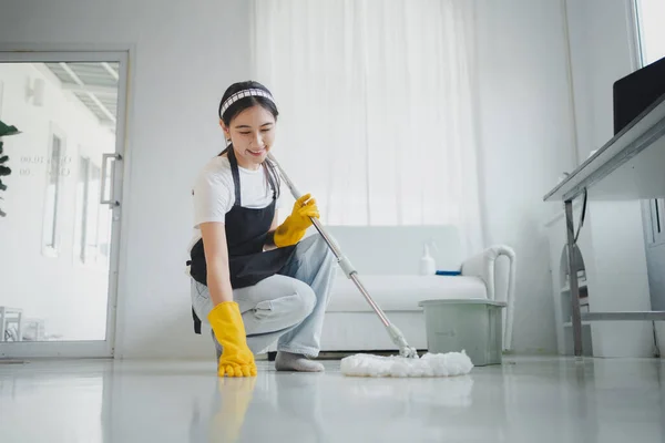 The cleaning staff is checking the floor to see if it is clean or not, Wear rubber gloves and an apron and work with a happy smile, working with cleaning chemicals, cleaning idea.