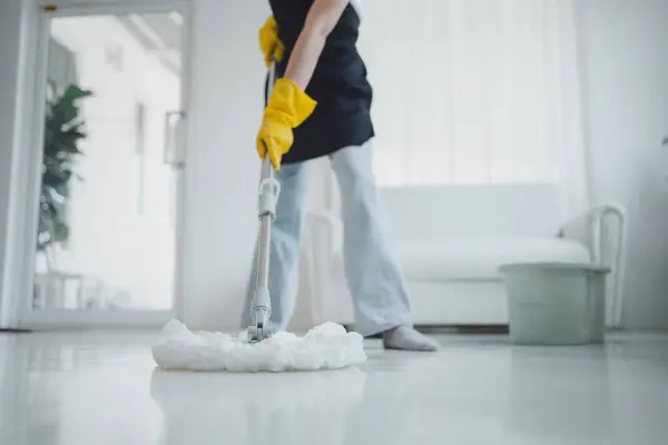 Cleaning staff mopping floors at home Wear an apron and rubber gloves to protect against cleaning chemicals. Use a mop to clean the floor. keep clean inside the house to prevent germs cleaning ideas.
