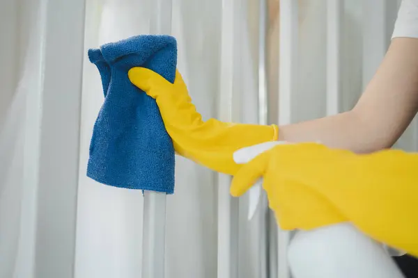 Housekeeper cleaning the furniture at home, Wear an apron and rubber gloves to protect against cleaning chemicals, female wiping down stairs with cleaning spray, cleaning idea.