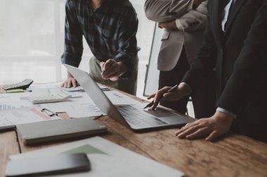 Gelirleri hesaplamak için birlikte çalışan bir grup işadamı, finansal rakamları gözden geçiriyorlar, finansal belgeleri çıkarıyorlar ve onları bir hesap makinesiyle, finansal fikirle kontrol ediyorlar..