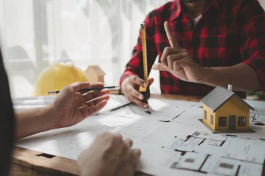 Yapısal işlerde kullanım için tasarım planları, toplantıda binaların yapısını çizin ve birlikte tartışın, mühendis mimarla bir ev inşa etme konusunda planlama yapıyor, mimar fikri.