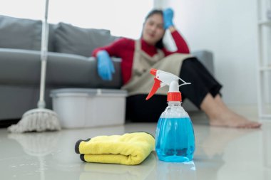 Ev işi yaparken oturup dinlenmek, yerleri paspaslarken yorgun hissetmek, temizlik kimyasallarına karşı korunmak için önlük ve lastik eldiven giymek, temizlik fikri..