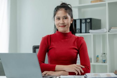 Bir çalışan konferansta sunulacak bir girişim hakkında bilgi arıyor, şirkette bir ofiste otururken çalışmak için bir dizüstü bilgisayar kullanıyor, başlangıç fikri sunmak için bilgi topluyor,.