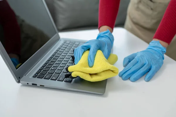 Janitor cleaning the office,  Clean the notebook with a rag, wear gloves and wipe with a towel, Wear rubber gloves when working with cleaning chemicals, cleaning idea.
