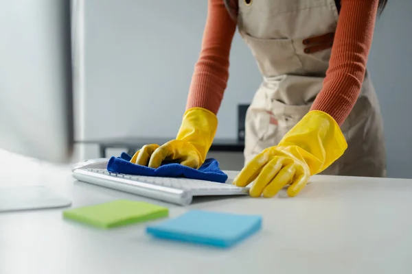 Cleaning staff wiping down office equipment, Wipe the keyboard clean with a towel and sanitizer, Wear rubber gloves when working with cleaning chemicals, cleaning idea.