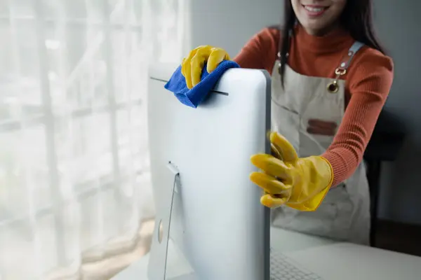 Janitor cleaning the office, Clean the monitor with a rag, wear gloves and wipe with a towel, Wear rubber gloves when working with cleaning chemicals, cleaning idea.